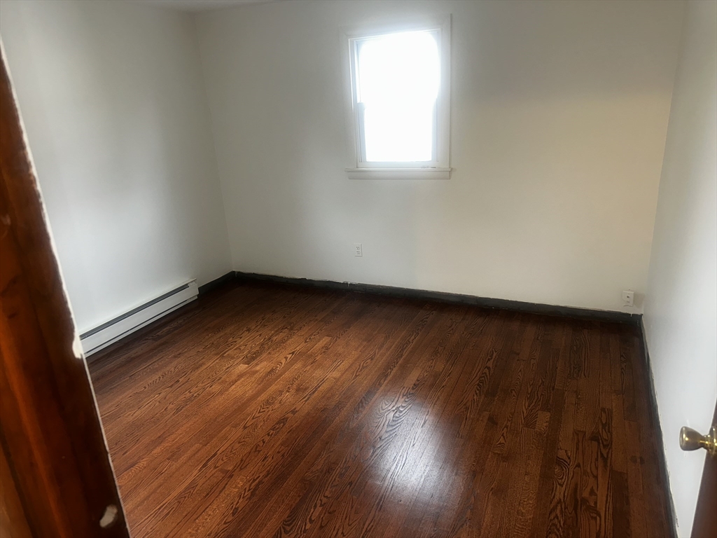 13 Decatur Street, Unit 13 Springfield, MA 01151 - Photo 4 of 7 an empty room with wooden floor and windows