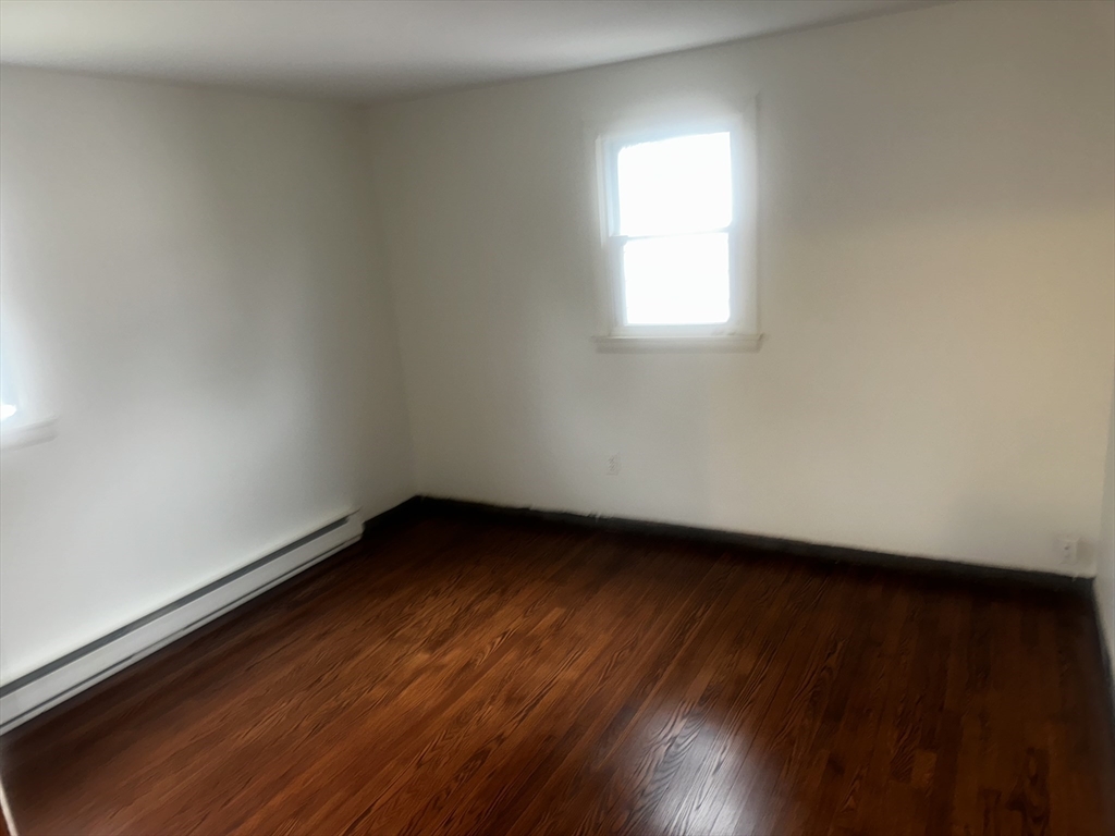 13 Decatur Street, Unit 13 Springfield, MA 01151 - Photo 5 of 7 an empty room with wooden floor and windows