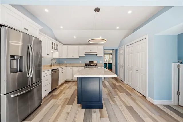 a kitchen with refrigerator a sink and wooden floor