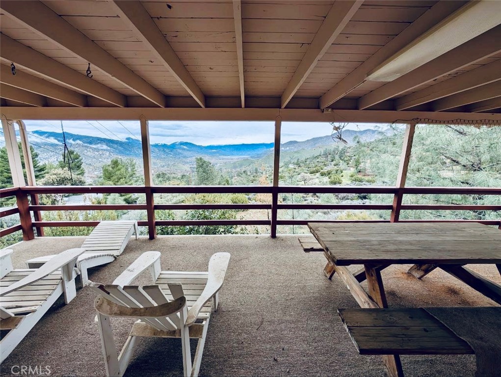 a view of a porch with furniture and wooden deck