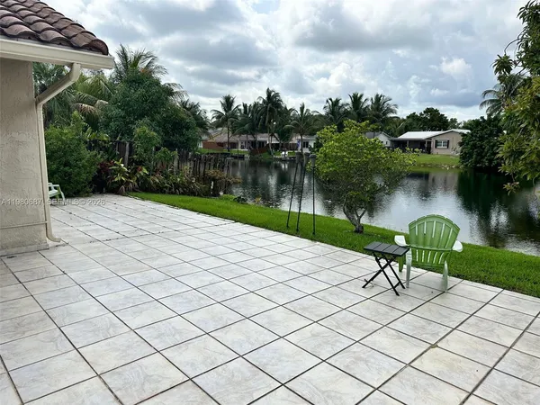 a view of a lake with a bench and trees around