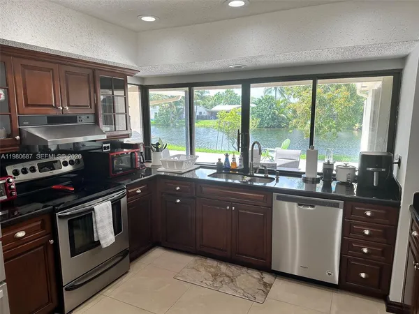 a kitchen with stainless steel appliances granite countertop a stove a sink and a microwave