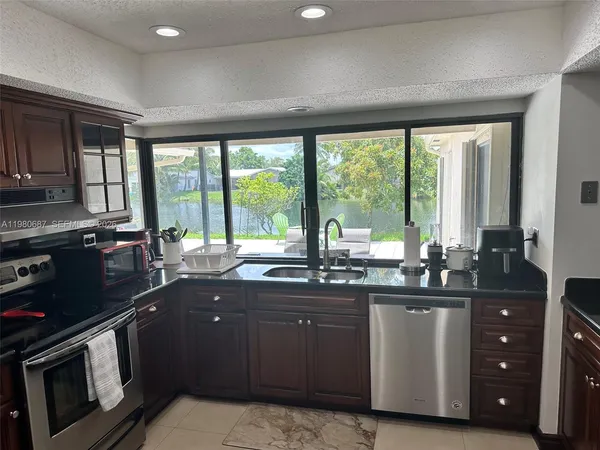 a kitchen with stainless steel appliances granite countertop a stove refrigerator and a refrigerator