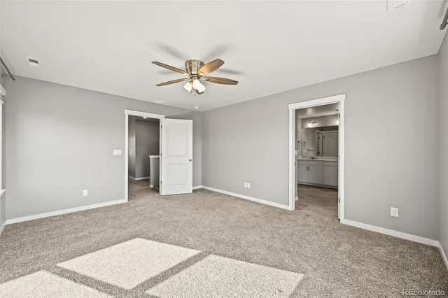 an empty room with closet and a ceiling fan