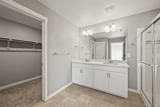 a spacious bathroom with a double vanity sink and a mirror