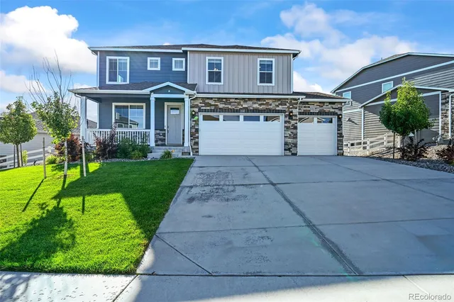 a front view of a house with a yard and potted plants