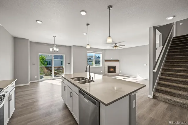 a kitchen that has a lot of cabinets a sink and wooden floor