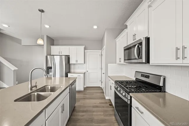 a kitchen with stainless steel appliances a sink stove and refrigerator