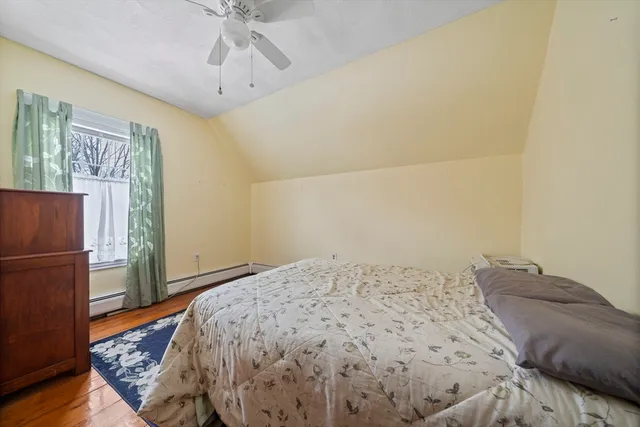 a bedroom with a bed and a refrigerator