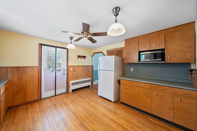 a kitchen with stainless steel appliances granite countertop a refrigerator a microwave oven a sink and dishwasher with wooden floor