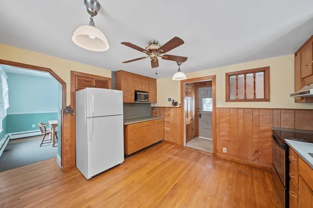 a kitchen with furniture a refrigerator and wooden floor