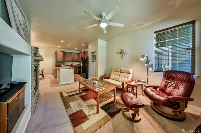 a living room with furniture a large window and gym equipment