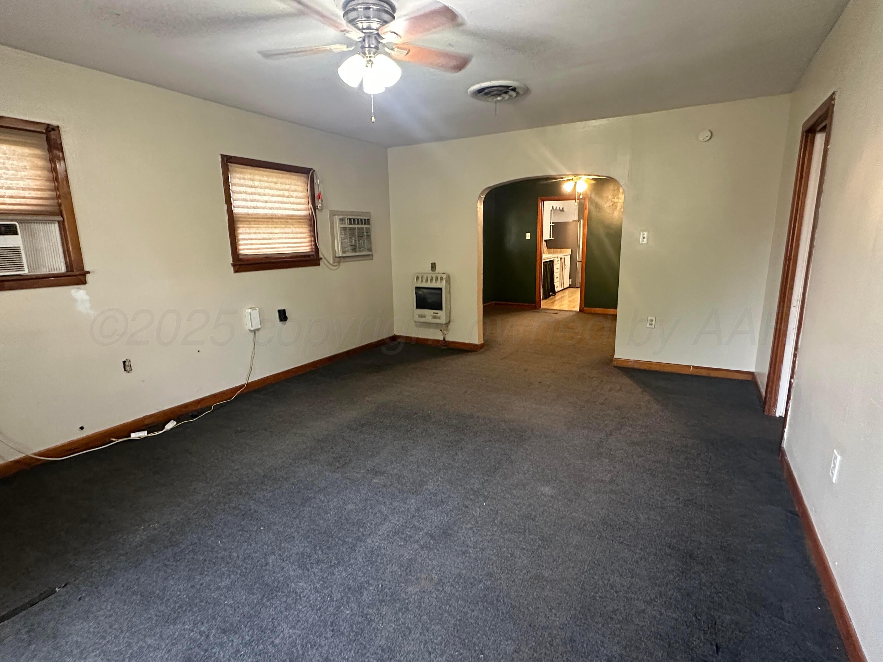 412 North 11th Street Memphis, TX 79245 - Photo 3 of 14 an empty room with chandelier fan and windows