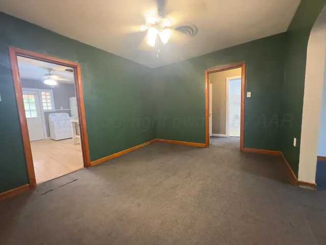 an empty room with closet and a chandelier fan