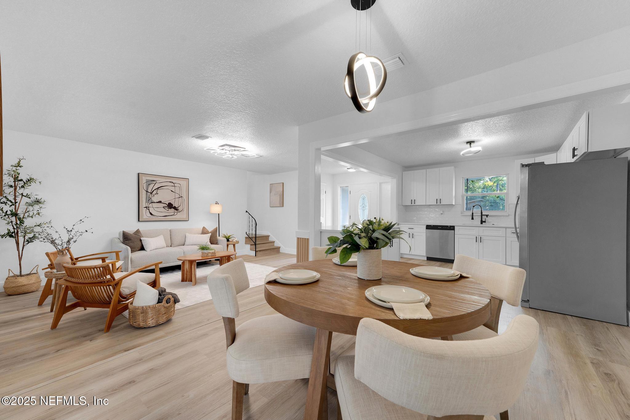 6537 Simca Drive Jacksonville, FL 32277 - Photo 12 of 25 a living room with furniture kitchen view and a chandelier