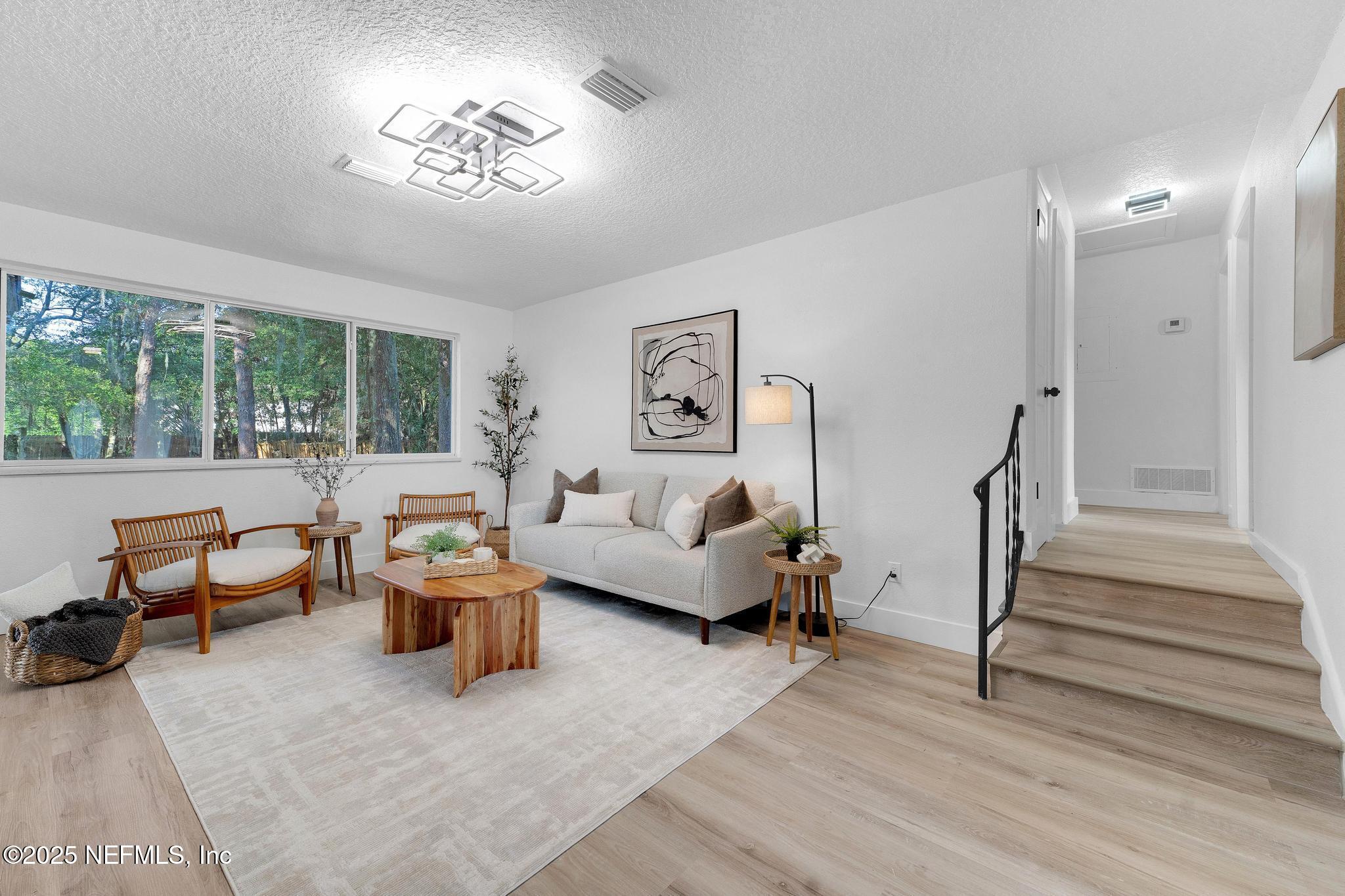 6537 Simca Drive Jacksonville, FL 32277 - Photo 14 of 25 a living room with furniture and a painting on the wall