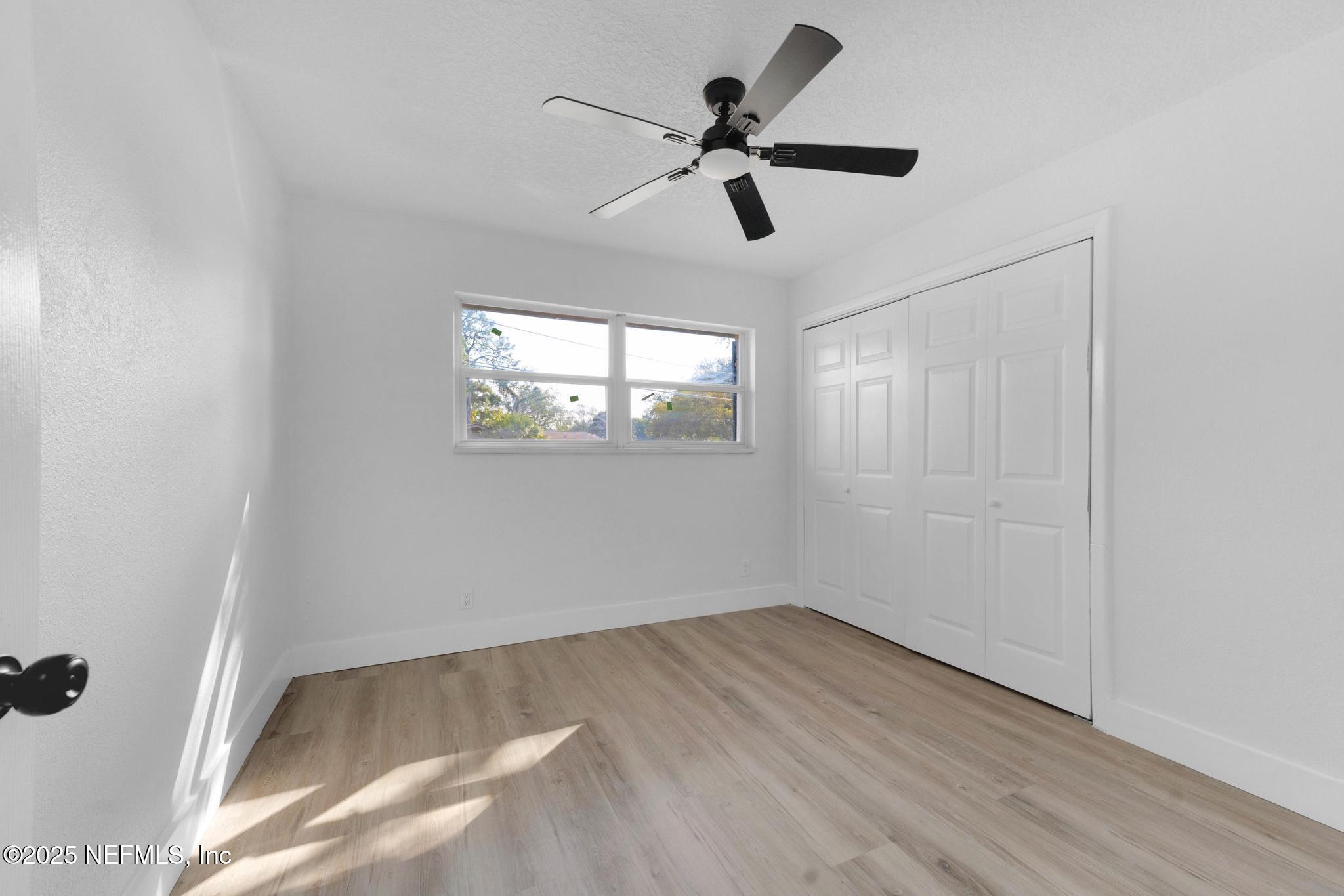 6537 Simca Drive Jacksonville, FL 32277 - Photo 16 of 25 a view of empty room with wooden floor and ceiling fan