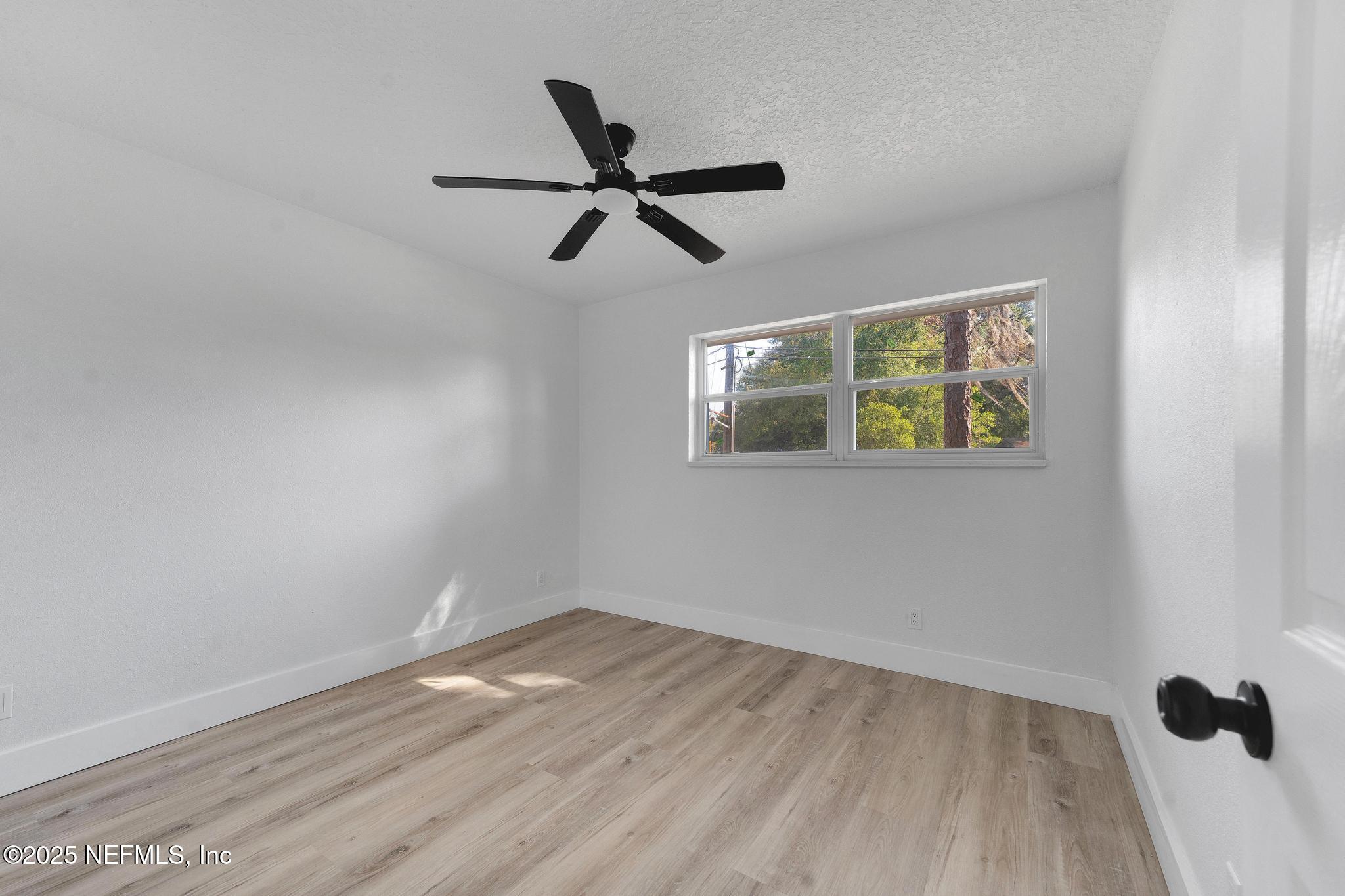 6537 Simca Drive Jacksonville, FL 32277 - Photo 17 of 25 a view of a big room with wooden floor ceiling fan and windows