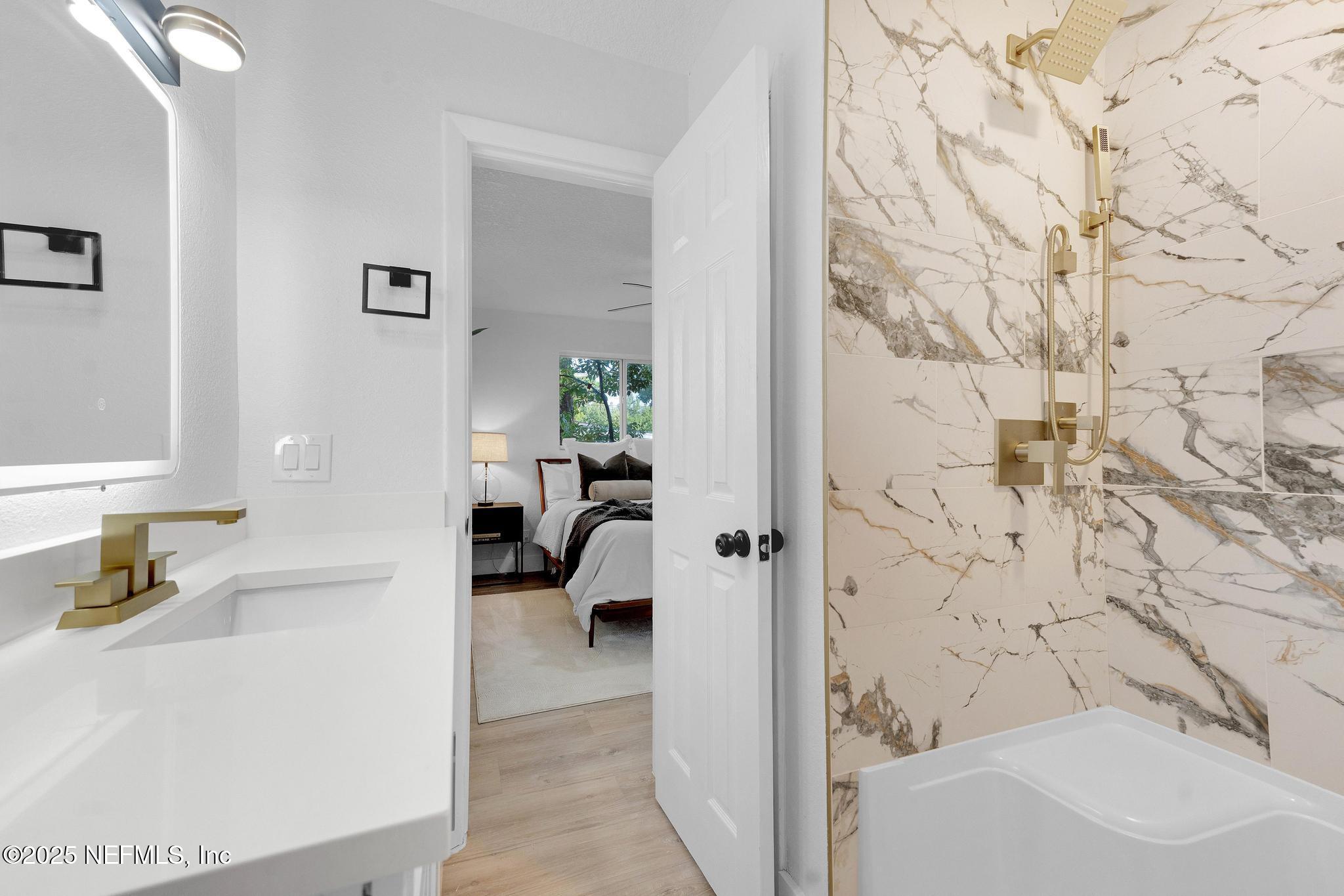 6537 Simca Drive Jacksonville, FL 32277 - Photo 22 of 25 a en suite bathroom with a sink and a bath tub