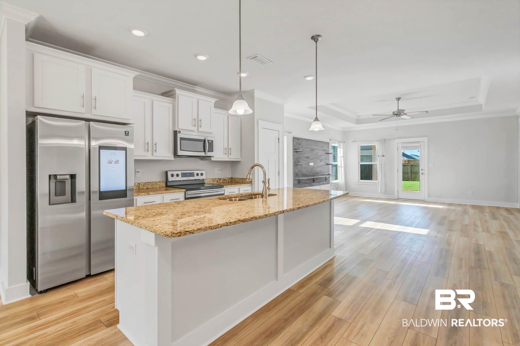 16461 Prado Loop Loxley, AL 36551 - Photo 10 of 78 Kitchen with a raised ceiling, stainless steel appliances, decorative light fixtures, white cabinets, and light stone counters