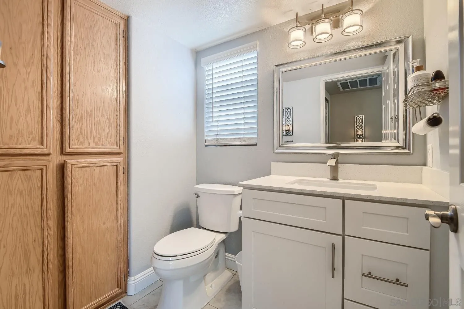418 Helix Way Oceanside, CA 92057 - Photo 10 of 22 a bathroom with a toilet sink vanity and mirror