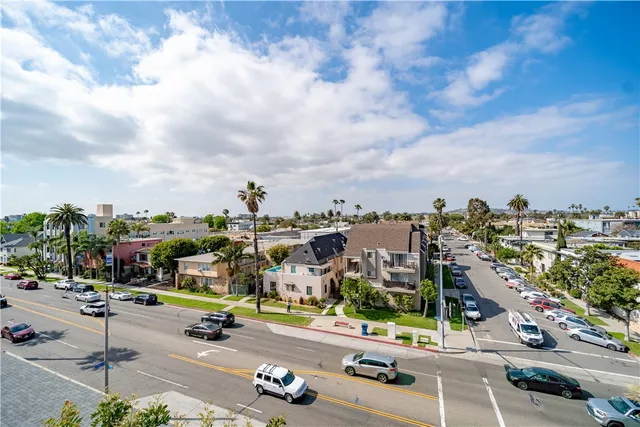 an empty room with wooden floor and windows with curtains