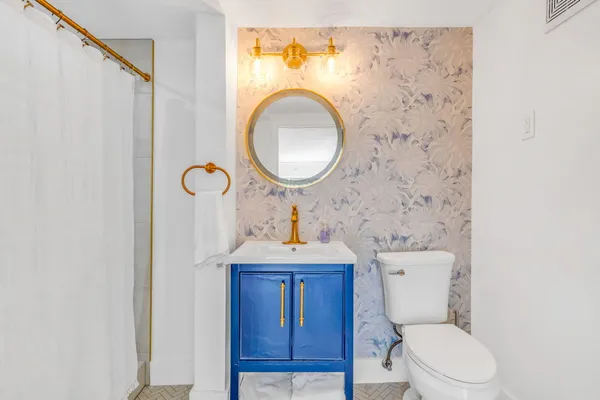 a bathroom with a toilet a sink and a mirror