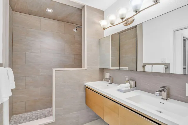 a bathroom with a double vanity sink mirror and shower