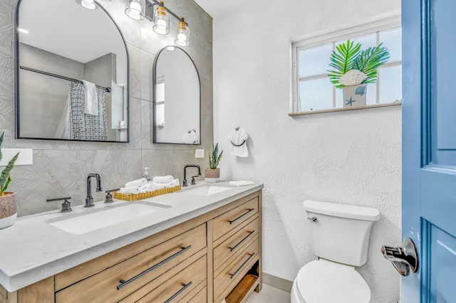 a bathroom with a granite countertop toilet sink and mirror