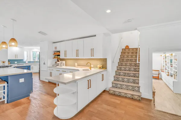 a large kitchen with kitchen island a sink stainless steel appliances and cabinets