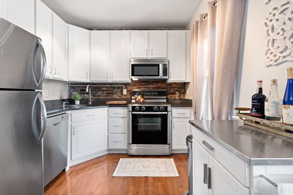 293 West 2nd Street, Unit 3 Boston, MA 02127 - Photo 4 of 25 a kitchen with granite countertop a refrigerator stove and microwave