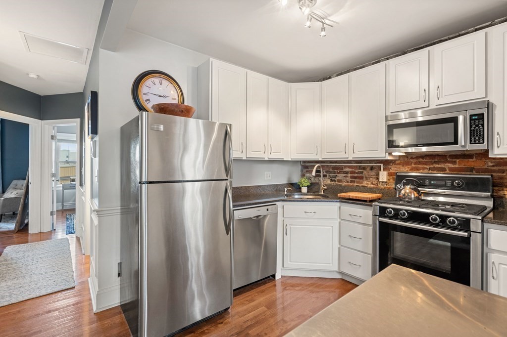 293 West 2nd Street, Unit 3 Boston, MA 02127 - Photo 5 of 25 a kitchen with cabinets stainless steel appliances and wooden floor