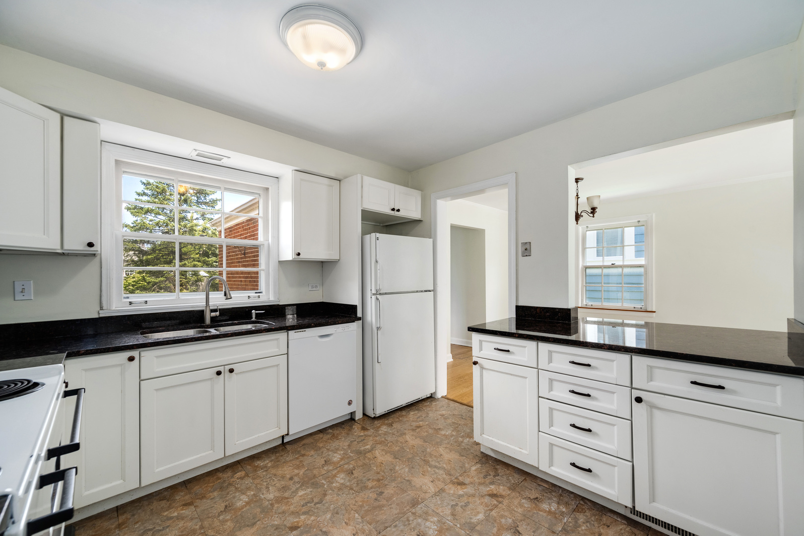 2104 Linneman Street Glenview, IL 60025 - Photo 5 of 19 a kitchen with granite countertop a sink cabinets stainless steel appliances and a window