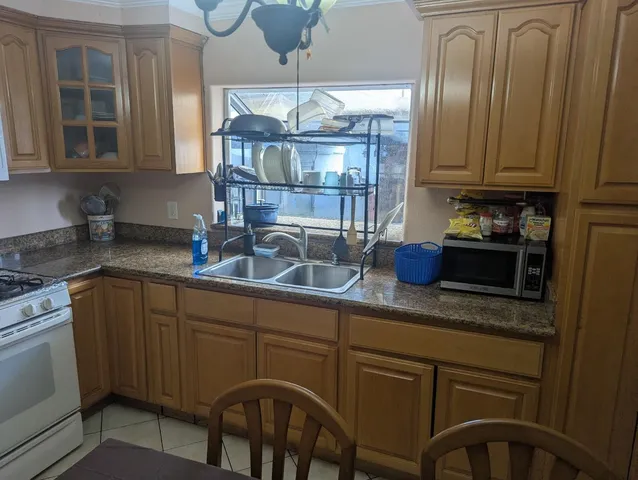 a kitchen with stainless steel appliances granite countertop a sink a stove and cabinets