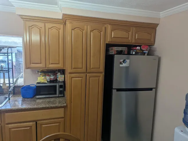 a kitchen with stainless steel appliances granite countertop a refrigerator and a stove