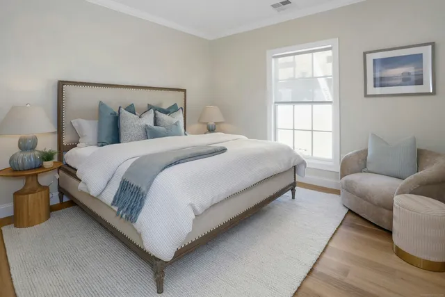a large bed sitting in a bedroom next to a window