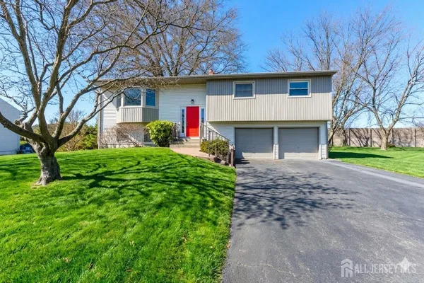 a front view of a house with garden and trees