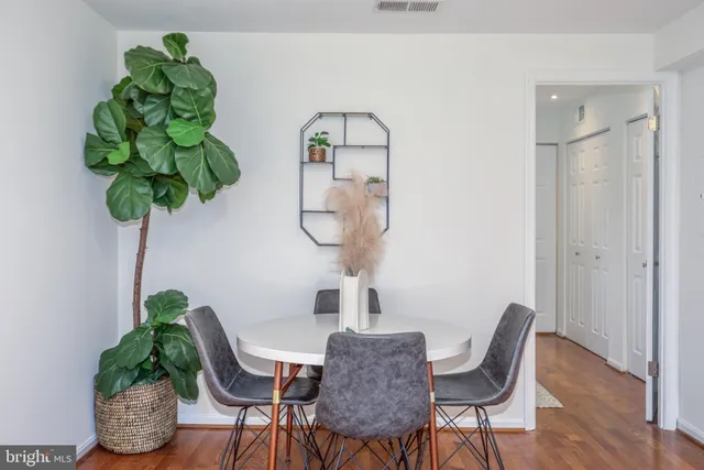 a vase of flowers sitting on a table with a potted plant
