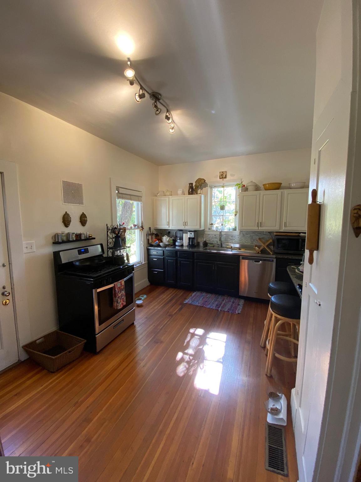 5713 Roland Avenue Baltimore, MD 21210 - Photo 7 of 29 a kitchen with stainless steel appliances kitchen island granite countertop a stove and a wooden floors
