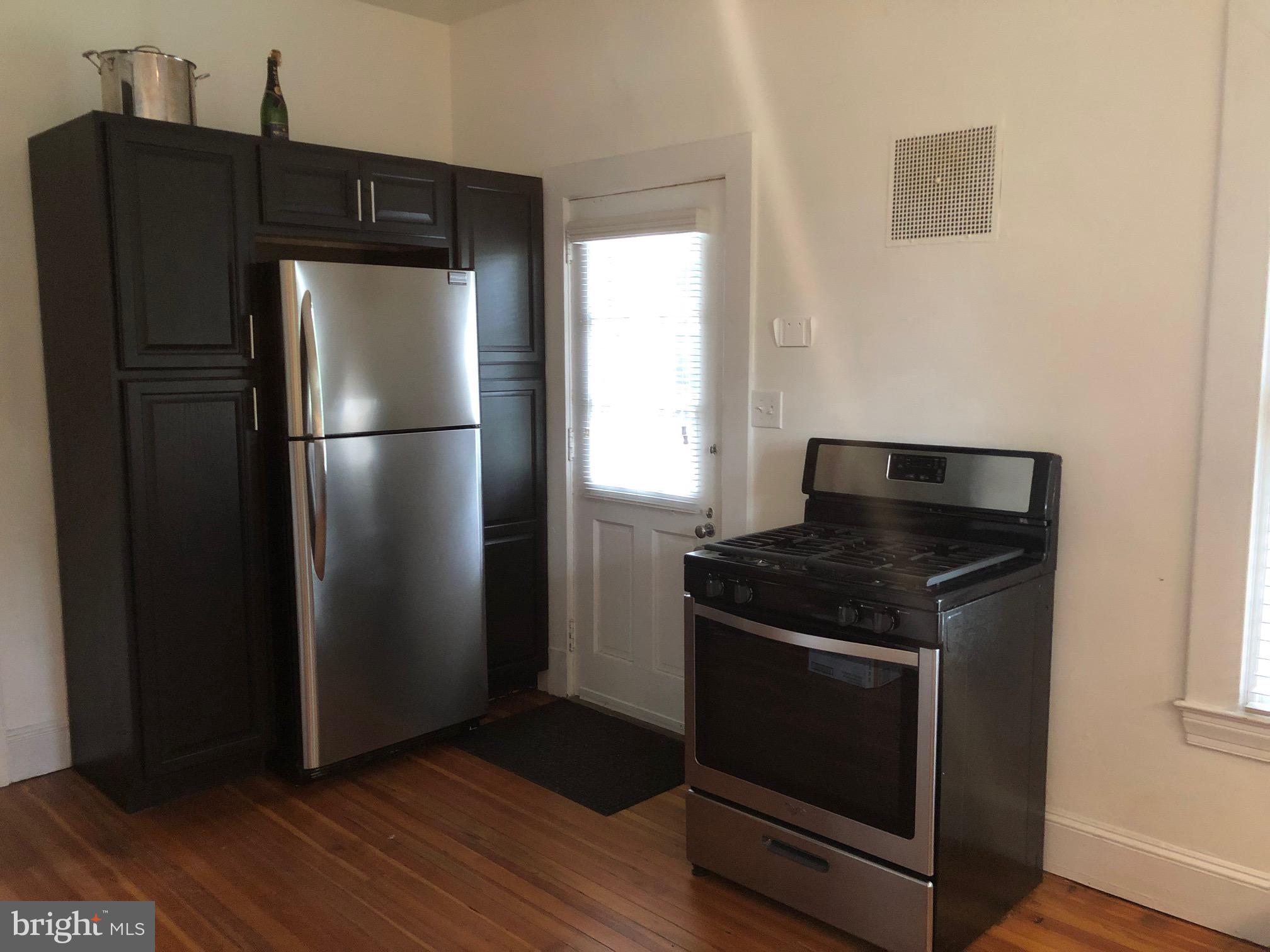5713 Roland Avenue Baltimore, MD 21210 - Photo 8 of 29 a kitchen with a refrigerator stove and cabinets