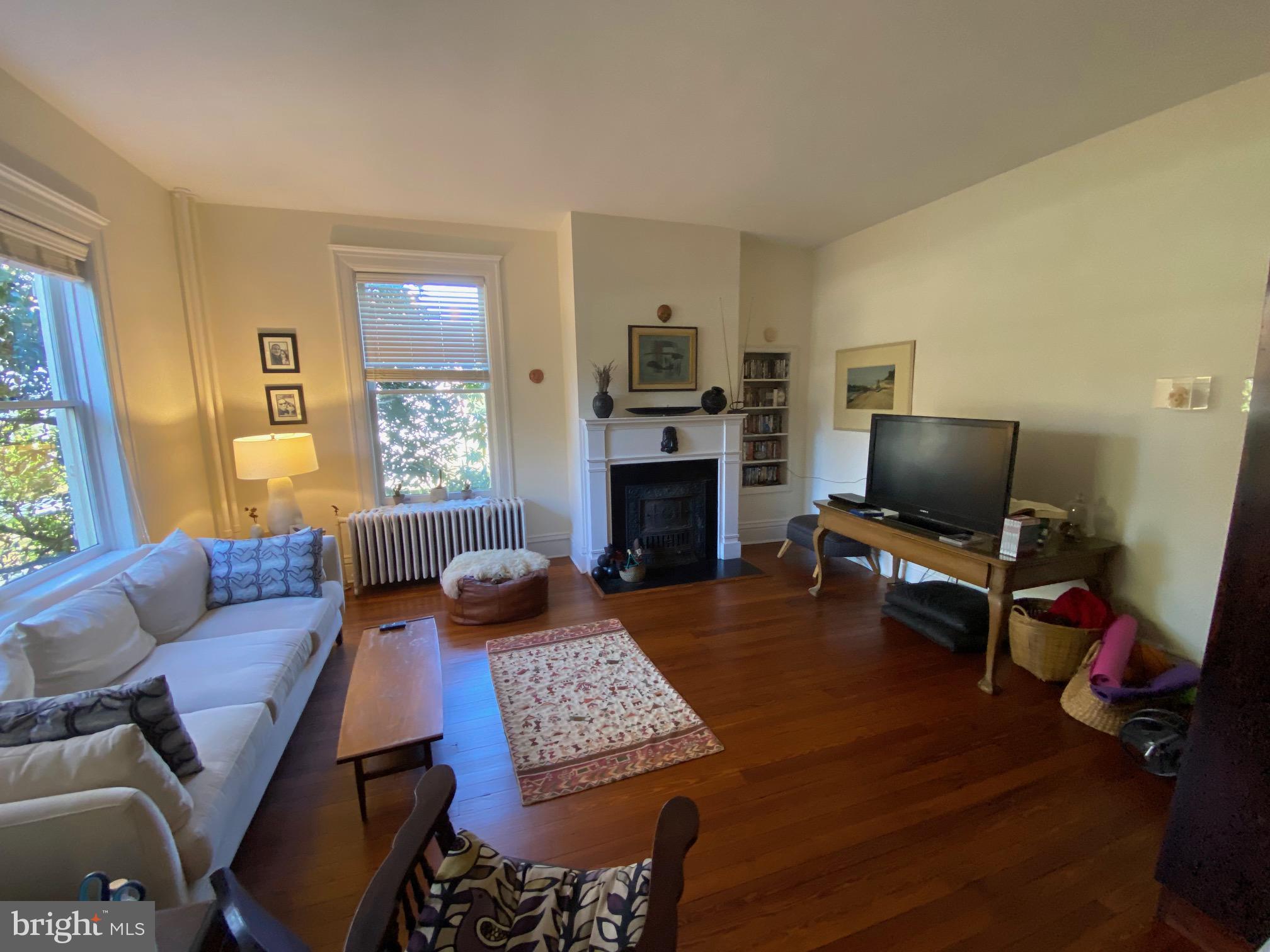 5713 Roland Avenue Baltimore, MD 21210 - Photo 10 of 29 a living room with furniture a flat screen tv and a fireplace