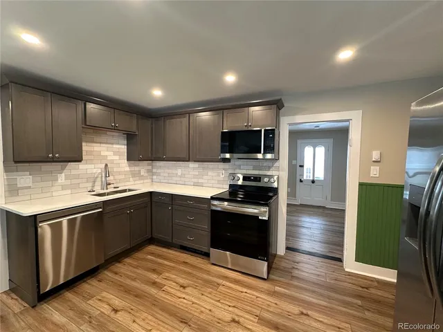a kitchen with granite countertop stainless steel appliances and wooden cabinets