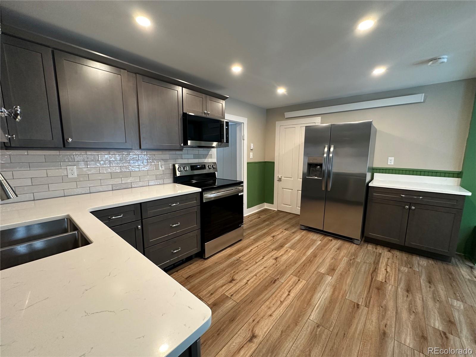 906 Main Street Georgetown, CO 80444 - Photo 15 of 28 a kitchen with stainless steel appliances kitchen island granite countertop a refrigerator a sink a stove a microwave and island