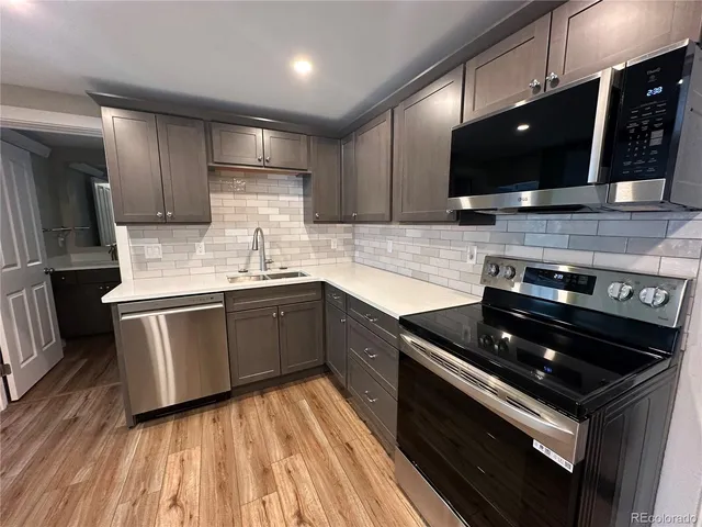 a kitchen with stainless steel appliances kitchen island granite countertop a stove a sink and a microwave