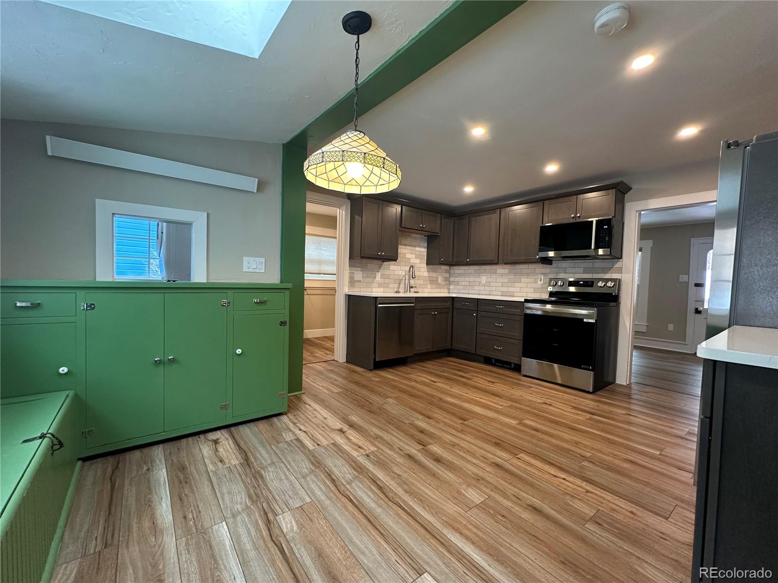 906 Main Street Georgetown, CO 80444 - Photo 18 of 28 a kitchen with kitchen island a sink dishwasher stove and oven with wooden floor