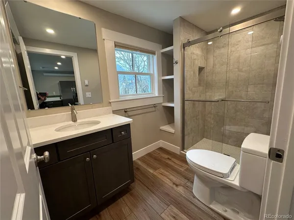 a bathroom with a sink toilet a mirror and shower