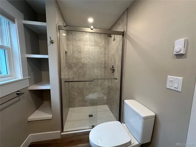 a bathroom with a shower a toilet and a sink