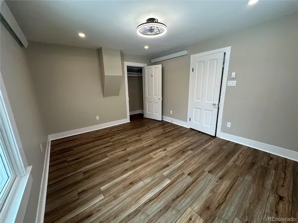 a view of an empty room with wooden floor