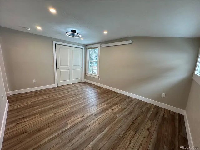 a view of an empty room with wooden floor