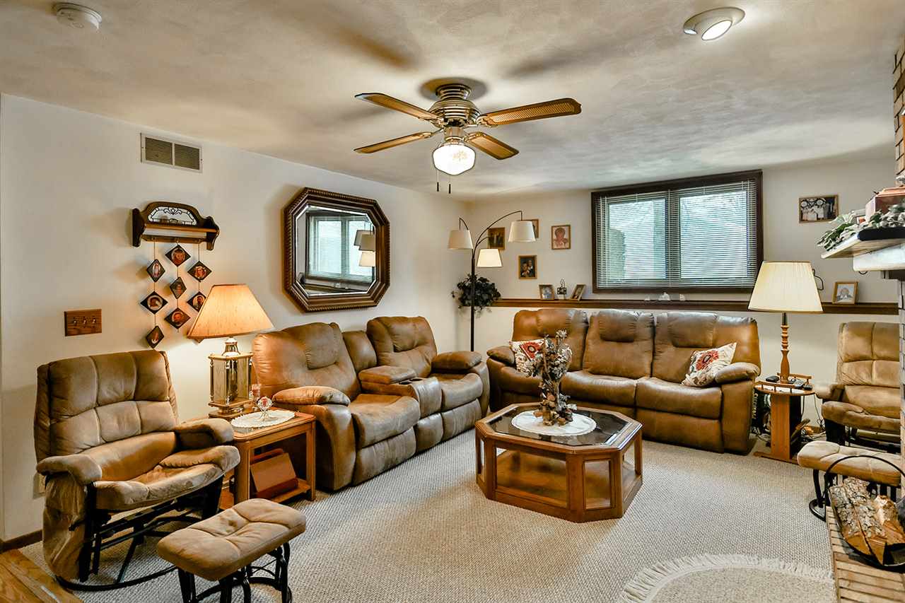 12944 Huntsboro Lane Roscoe, IL 61073 - Photo 29 of 40 a living room with furniture a chandelier and a ceiling fan